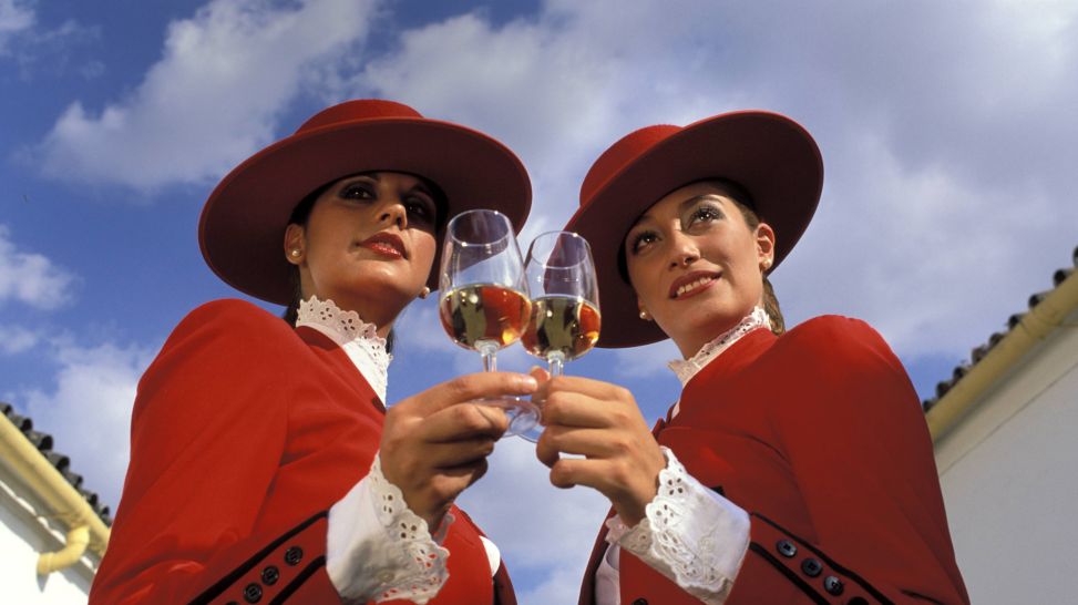 Zwei Frauen in AndalusischeTrachten Bolero und Hut mit Sherrygläsern (Quelle: imago/imagebroker/WhiteStar)