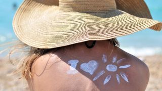 Frau mit Sonnenhut am Strand - Symbolbild Sonnenschutz (Bild: Colourbox)