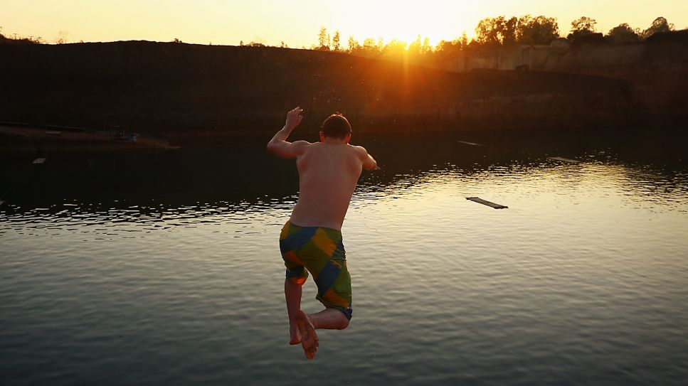 Mann springt bei Sonnenuntergang in einen See (Bild: Colourbox)