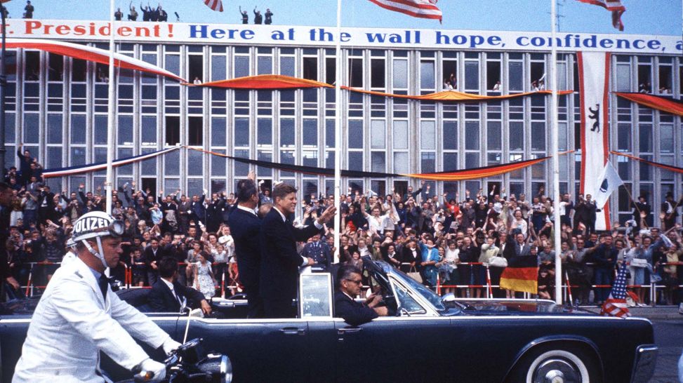 John F. Kennedy, Willy Brandt und Konrad Adenauer im Auto vor jubelnde Meschen (Quelle: picture-alliance/Sven Simon)