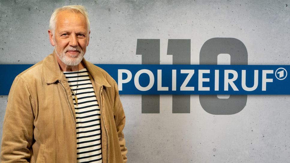 Schauspieler Frank Leo Schröder vor Wand mit "Polizeiruf 110"-Logo (Bild: rbb/Thomas Ernst)