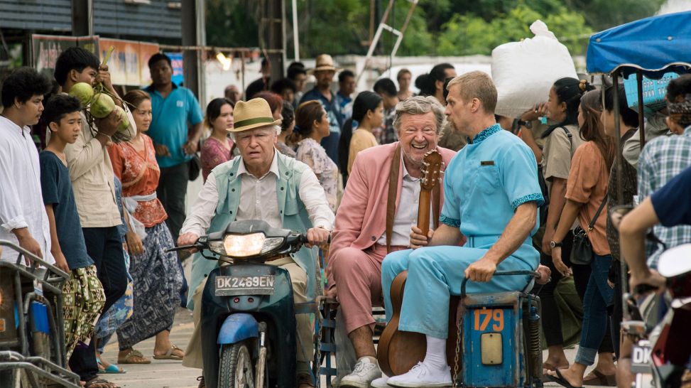 Allan (Robert Gustafsson), Benny (David Wiberg) und Gäddan (Jens Hultén) machen sich auf einem Moped mit Beiwagen in Bali aus dem Staub; Szene aus dem Film"Der Hunderteinjährige, der die Rechnung nicht bezahlte und verschwand" (Bild: ARD Degeto/Tele-München)