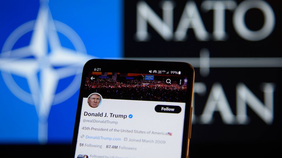 USA- und NATO-Illustrationen. Der Account des ehemaligen Präsidenten der Vereinigten Staaten von Amerika, Donald Trump, auf der Social-Media-Plattform X ist am 11. Februar 2024 in Warschau, Polen, auf einem Smartphone-Bildschirm vor einem NATO-Logo abgebildet (Bild: IMAGO / Aleksander Kalka)