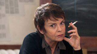 Dunja (Katrin Sass) sitzt rauchend am Tisch. Sie muss befürchten, dass ihre Tätigkeit als IM herauskommt; Szene aus der Serie "Weissensee: Einer von uns"; Quelle: ARD/Julia Terjung