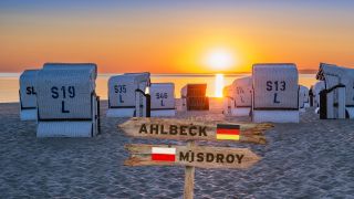 Fotomontage: Wegweiser "Ahlbeck" und "Misdroy" vor Strandkörben im Sonnenuntergang auf Usedom an der Ostsee (Bild: rbb/picture alliance/Zoonar|Andreas Völkel/colourbox)
