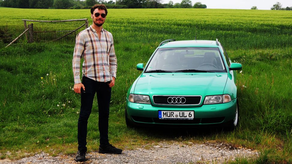 Mann steht vor einem grünen Auto (Quelle: Elia Brose)