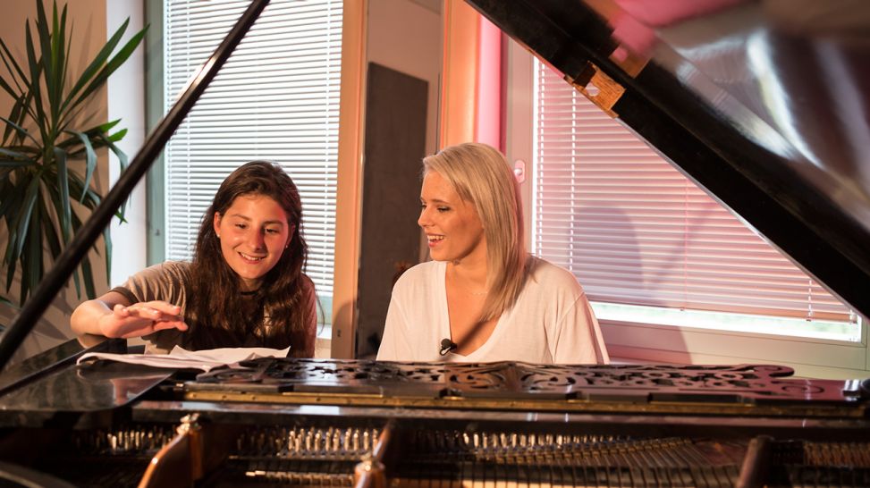 Saengerin Lissi mit Jini von Luxuslaerm am Klavier in der Musikschule 1 - (C) NINA HANSCH DOKfilm