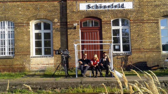 Das Team macht Pause auf einer Bank in Dutschkes Geburtsort Luckenwalde (Quelle: rbb)