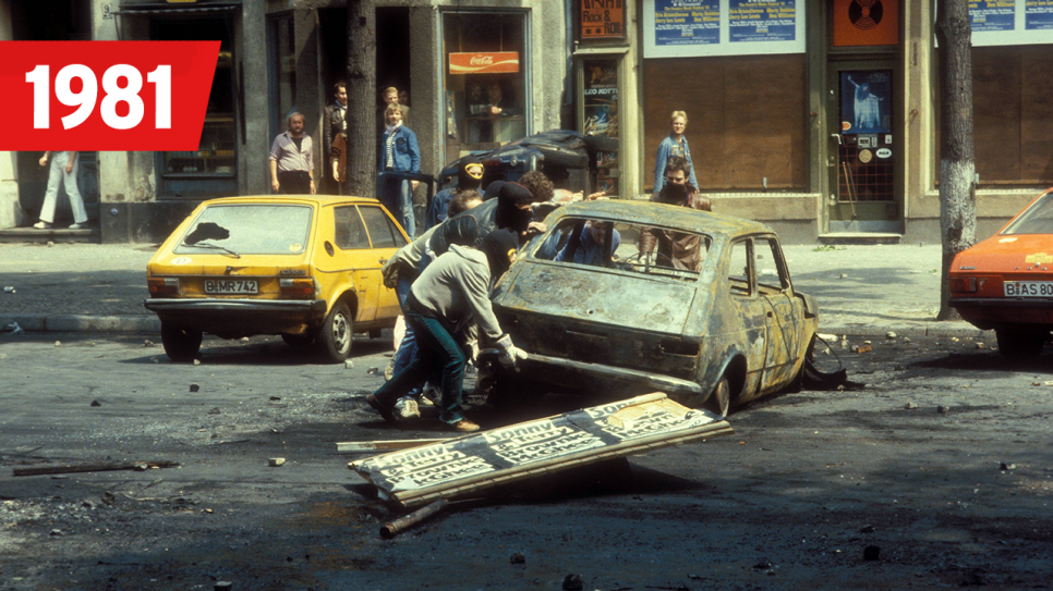 Zerstörte Autos - Autonome während einer Straßenschlacht in Berlin, Schriftzug 1981, Bild: imago images/Sven Simon