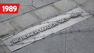 Stacheldraht liegt auf einer Plakette der ehemaligen Berliner Mauer in Berlin, Bild: imago images / Steinach