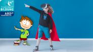 Happy boy dressed up as a superhero feels in the game while using VR glasses (Quelle: Photographee.eu)