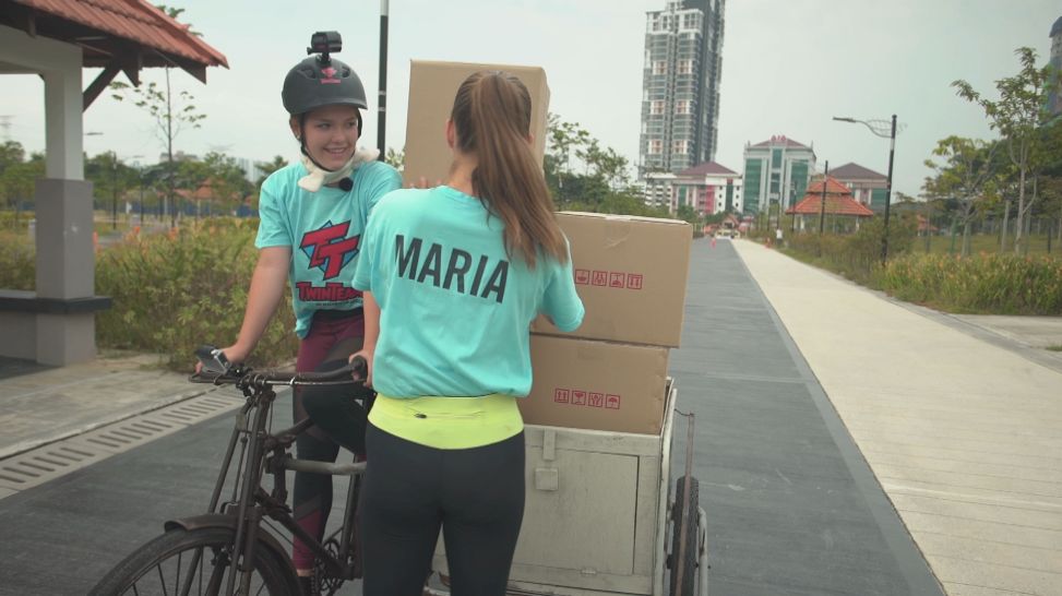 Kuala Lumpur; Hochstapler-Challenge Folge 16_Maria stapelt Kartons auf das Transportfahrrad; rbb/Dokfilm