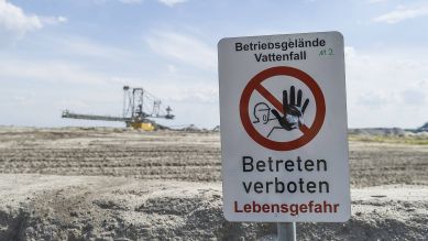 Schild mit "Bertriebsgelände Vattenfall, Betreten Verboten Lebensgefahr" vor Tagebaugelände (Bild: IMAGO / Markus Heine)
