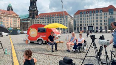 Ein feuerroter Wohnwagen und viele kleine Parteien: Gespräch auf dem Dresdener Altmarkt (Bild: rbb)