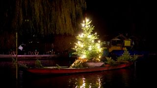 Spreewaldweihnacht: Ein beleuchteter Weihnachtsbaum steht auf einem Kahn im Hafen von Luebbenau, Foto: picture alliance/Andreas Franke