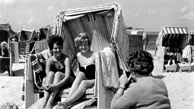 Junge Frauen in einem Strandkorb am Sandstrand von Binz auf Rügen werden für ein Erinnerungsfoto an ihren Urlaub im Juli 1961 von einer älteren Bekannten fotografiert (Bild: picture-alliance / dpa | ZB Burmeister)