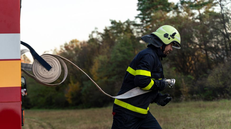 Feuerwehrmann rollt Schlauch ab (Bild: Colourbox)