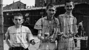 Junge Überlebende hinter einem Stacheldrahtzaun im Konzentrationslager Buchenwald (Quelle: rbb/National Archives and Records Administration, College Park)