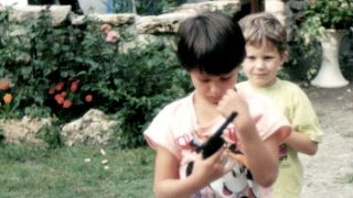 Andrea Hanna Hünniger: Kurz nach der Wende stolz in rosa, mit Mickey Maus und Spielzeugpistole (Quelle: rbb/MDR/Looks Film)