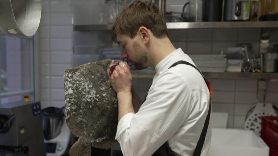 Tim Sillack begutachtet Steinbutt in der Küche (Bild: rbb/Jan Urbanski)