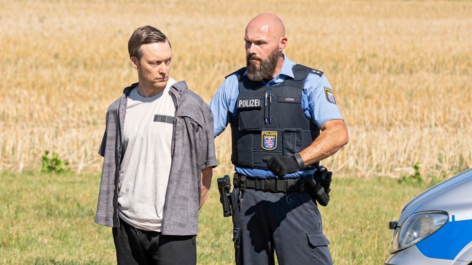 Stephan Ernst (Robin Sondermann) wird von einem Polizeibeamten an den Tatort geführt (Bild: HR/Daniel Dornhoefer)