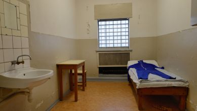Ein Bett, ein Waschbecken und ein kleiner Tisch in einer Stasi-Gefängniszelle.