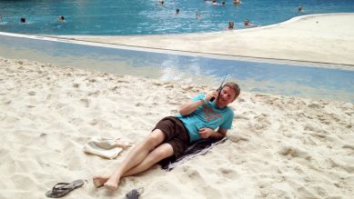 Michael Kessler liegt im Tropical Islands auf dem Sand und telefoniert (Bild: rbb/Oliver Ziebe)