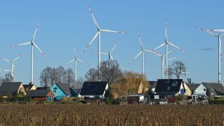 Der Windenergiepark «Odervorland» im Landkreis Oder-Spree hinter Einfamilienhäusern. Bild: Patrick Pleul/dpa-Zentralbild