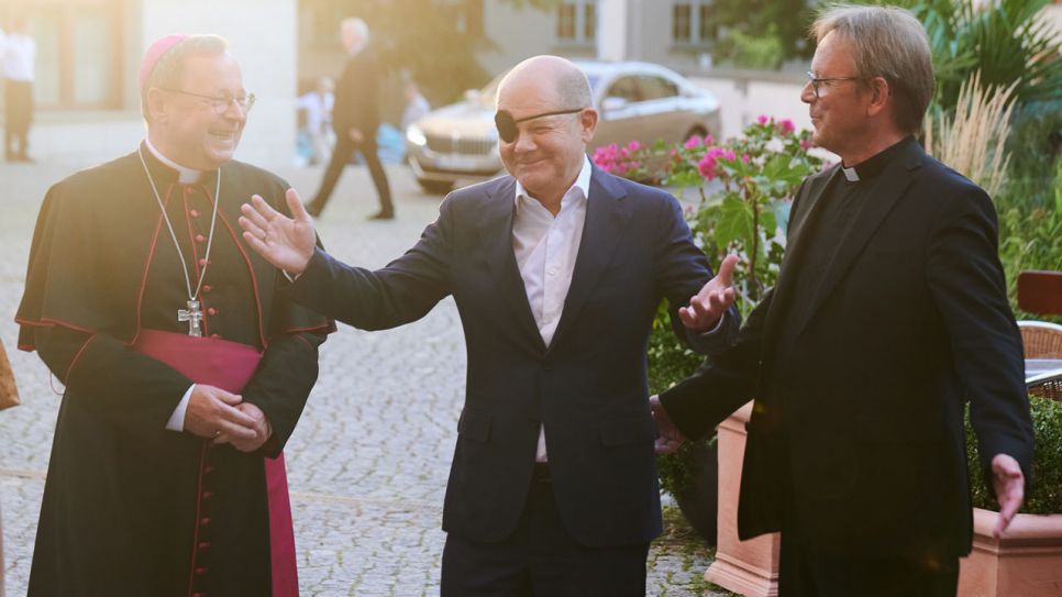 Bundeskanzler Olaf Scholz (M, SPD) kommt zum St.-Michael-Jahresempfang der Katholischen Kirche und wird von Georg Bätzing (l), Vorsitzender der Deutschen Bischofskonferenz, und Karl Jüsten (r), Leiter des Kommissariats der Deutschen Bischöfe, begrüßt. Bild: Annette Riedl/dpa