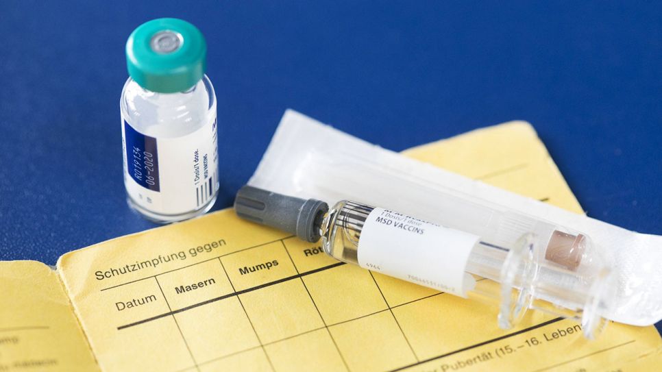 Impfstoff zur Impfung gegen Masern auf einem Impfpass. Quelle: imago/Ute Grabowsky / photothek.net