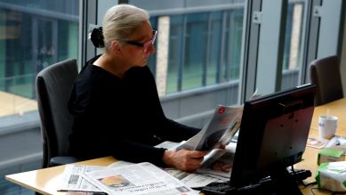 Ewa Wanat liest Zeitung am Schreibtisch