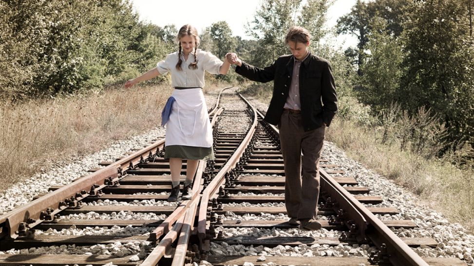 Franka und Romek laufen, Hand in Hand, auf Bahngleisen (Quelle: Robert Palka)