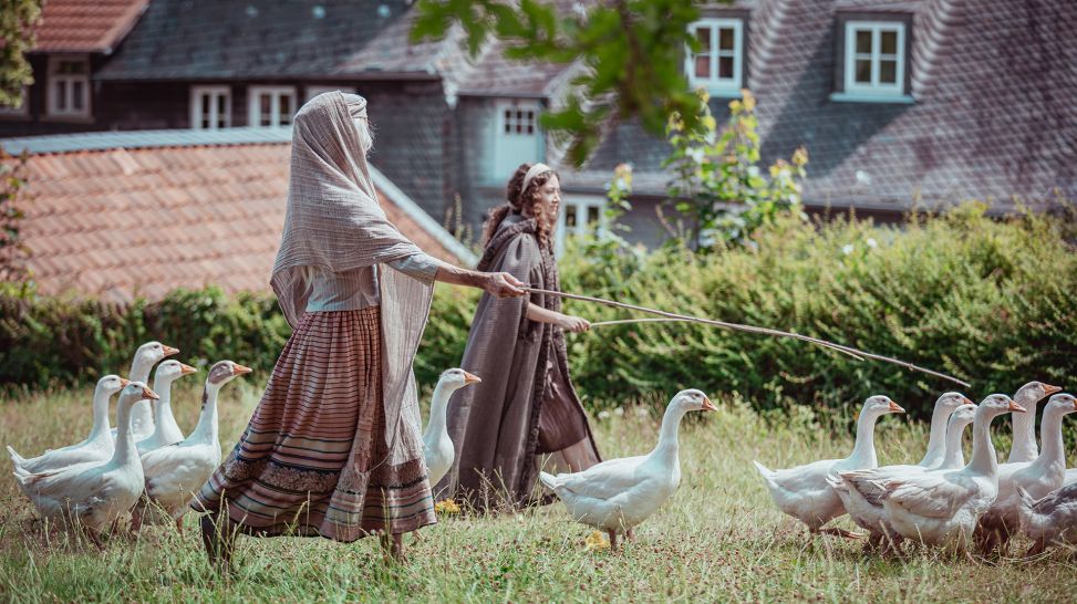 "Die Gänseprinzessin": Die magische Alte (Leslie Malton) und Prinzessin Polly (Mina Christ) treiben die Gänse ins Dorf, Foto: SWR/Alina Hartwig
