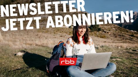 Newsletter abonnieren, Wanderin mit Laptop auf Bergwiese (Quelle: imago images/Westend61)