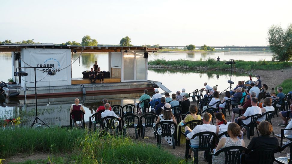Sitzende Gäste vor dem Traumschüff - Theater im Fluss (Quelle: rbb/M. Oosterkamp)