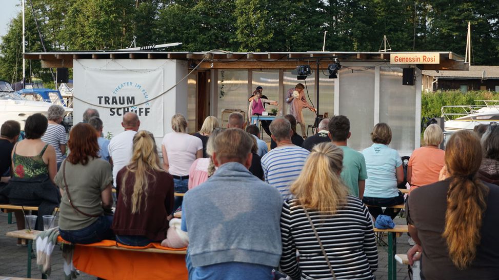 Sitzende Gäste vor dem Traumschüff - Theater im Fluss (Quelle: rbb/M. Finger)