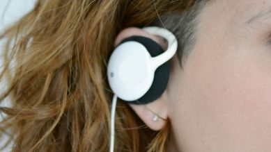 Weißer On-Ear-Kopfhörer am Ohr einer Frau