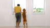 Mann und Hund schauen aus dem Fenster einer leeren Wohnung (Quelle: colourbox)