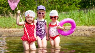 Drei kleine Mädchen stehen im See und haben Spaß (Quelle: colourbox)