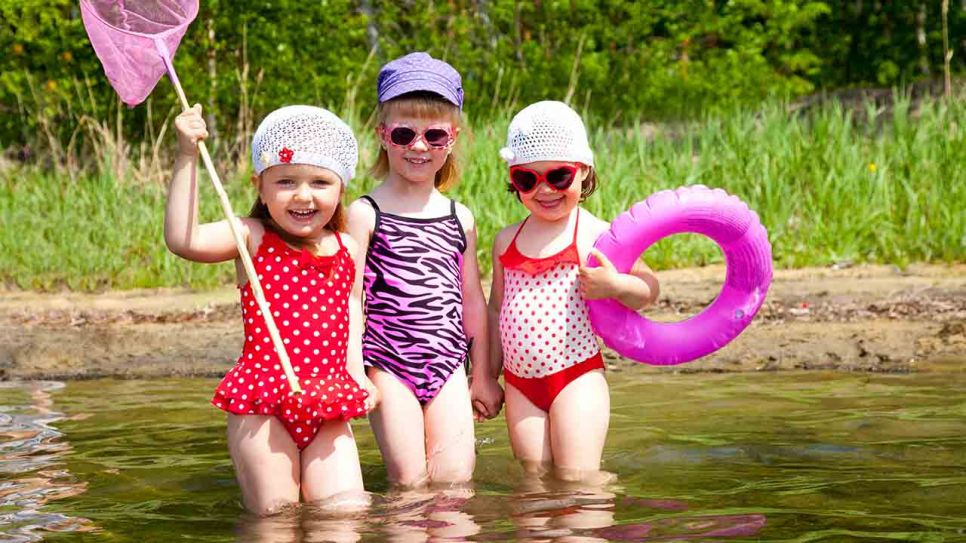Drei kleine Mädchen stehen im See und haben Spaß (Quelle: colourbox)