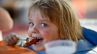 Mädchen isst eine Wurst mit der Gabel (Quelle: imago/Annett Mirsberger)