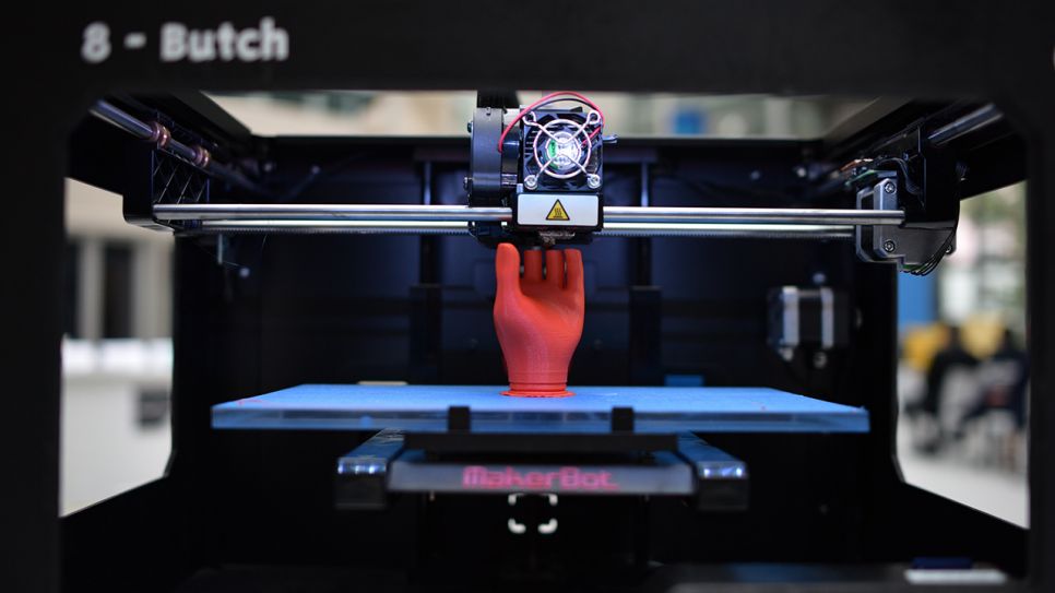 Der 3D-Drucker MakerBot druckt ein rotes Hand-Modell (Quelle: dpa/Christian Platz)
