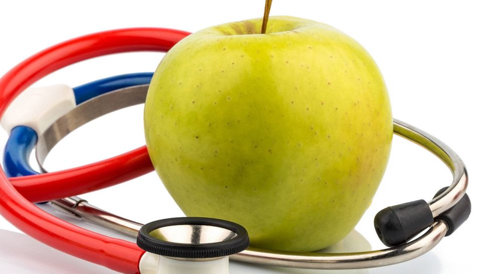 Stethoskopum einen Apfel geschlungen (Quelle: imago/blickwinkel)