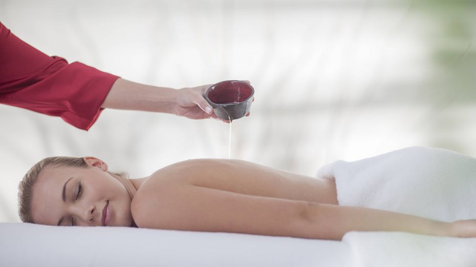 Frau bekommt eine Massage mit ätherischen Ölen (Quelle: imago/Westend61)