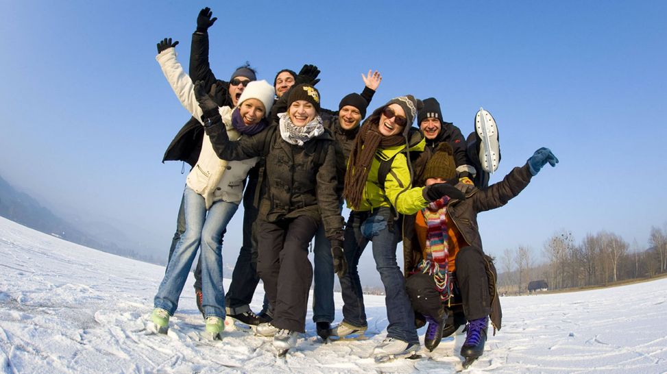 Eine Gruppe fröhlicher junger Menschen am Eislaufplatz (Quelle: imago/blickwinkel)
