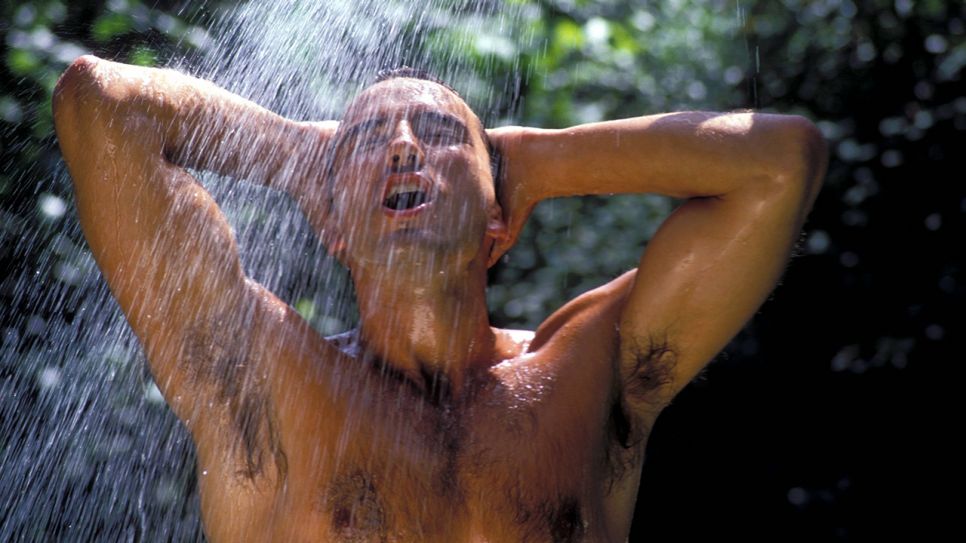Junger Mann erfrischt sich mit einer kalten Dusche (Quelle: imago/K-P Wolf)