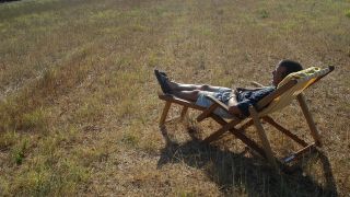 Mann auf dem Liegestuhl auf einem vertrocknetem Rasen (Quelle: colourbox)