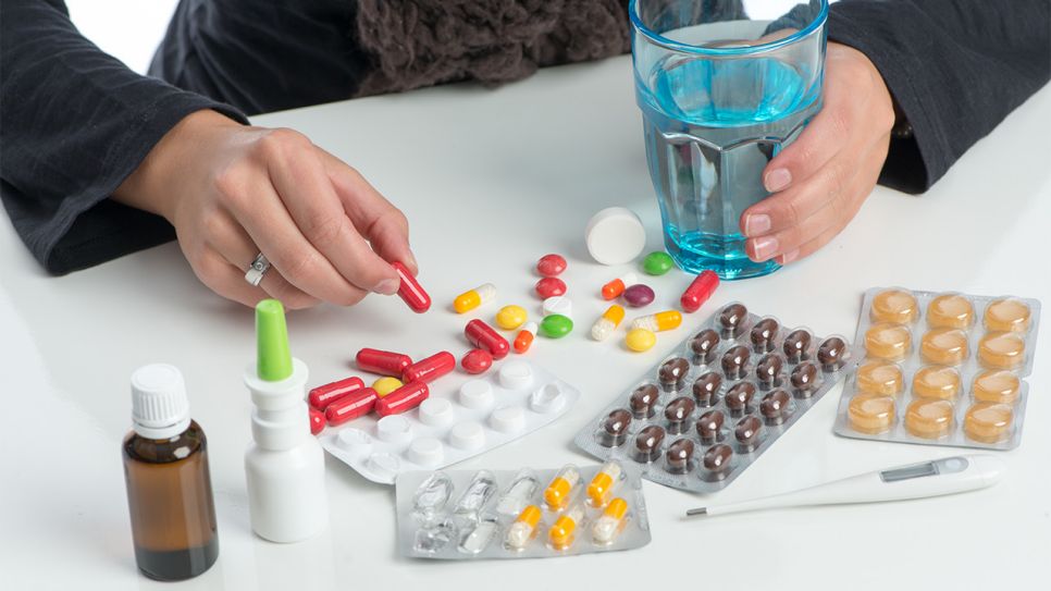 Pillen, Tabletten, Nasenspray und ein Glas Wasser auf einem Tisch (Bild: Colourbox)