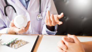 Hände eines Doktors halten Tabletten mit erklärender Gestik (Bild: Colourbox)