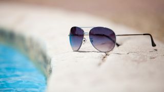 Sonnenbrille auf Poolrand (Quelle: colourbox)